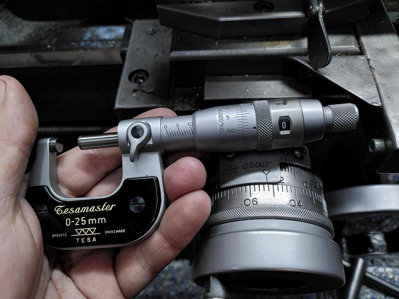 A Tesamaster 0-25mm micrometer held in a hand above the cross slide of a
metal working lathe. The micrometer is showing 10.006mm.